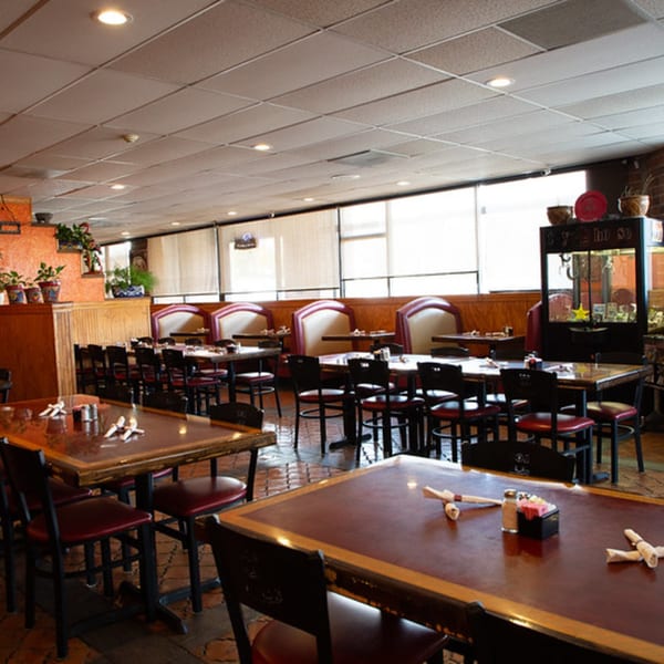 Interior of Los Compas Independence restaurant with tables, chairs, and booths, ready for diners.