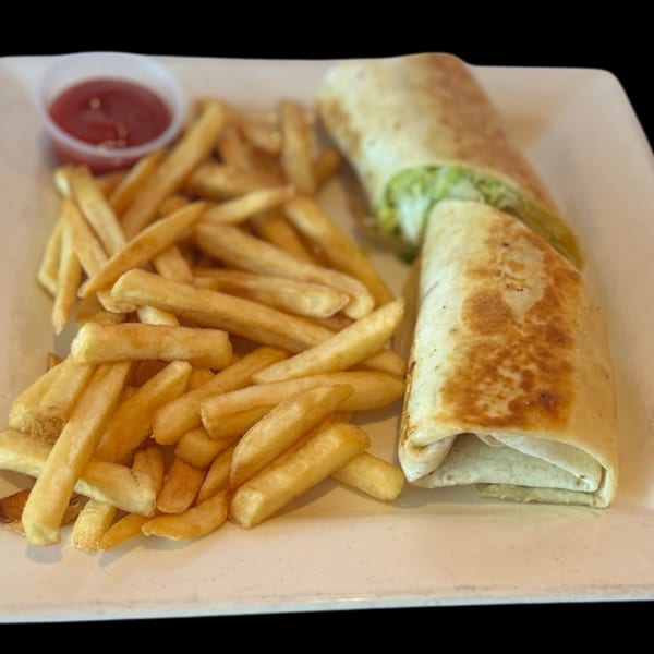Two grilled burritos with green filling and a side of golden french fries with ketchup.